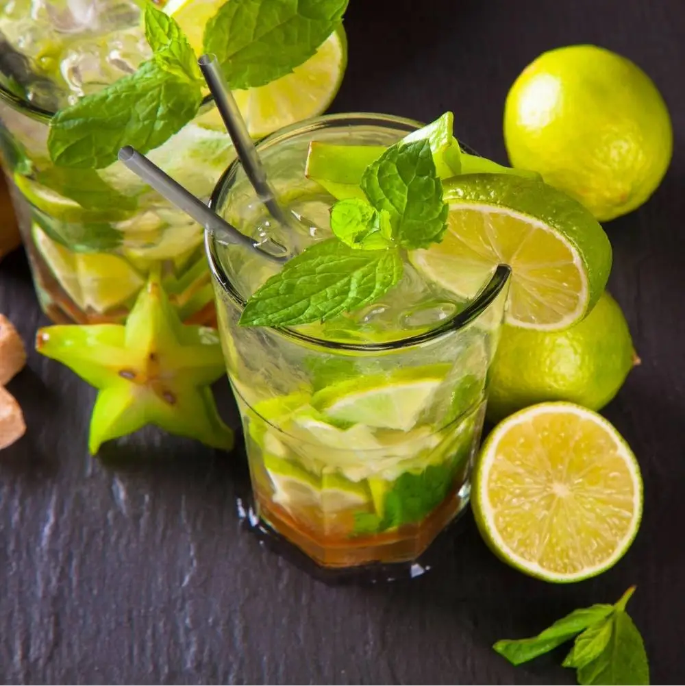 A Caipirinha cocktail with limes sitting on bar around the glass